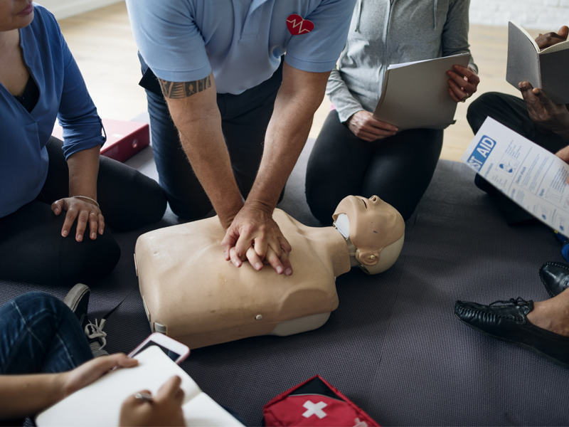 group of people practicing cpr on a dummy.